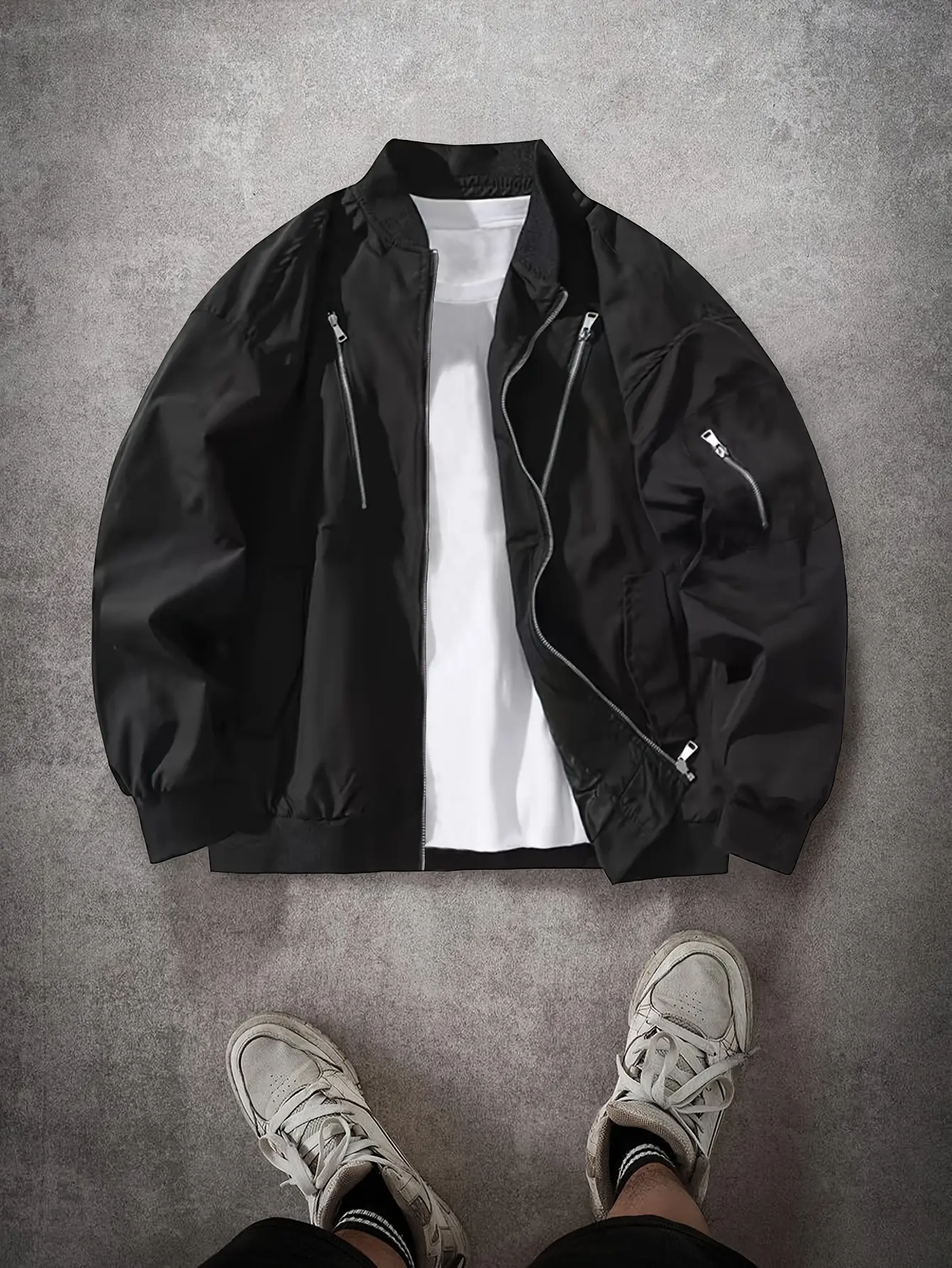 Men’s black casual bomber jacket with a stand collar, featuring multi‑metal zipper pockets and a ribbed cuff design; made from windproof fabric that is wear‑resistant and tear‑resistant—an urban commuter casual outerwear piece.