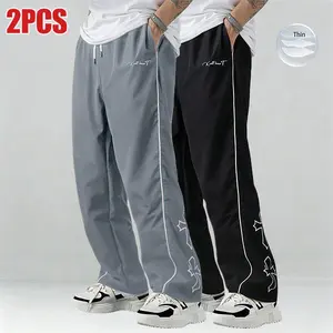 Men’s two-piece color-block sweatpants set featuring white side stripes and embroidered details; casual fitness wear; loose-fit joggers; trendy street-style running pants; drawstring waist; straight cut; polyester fabric