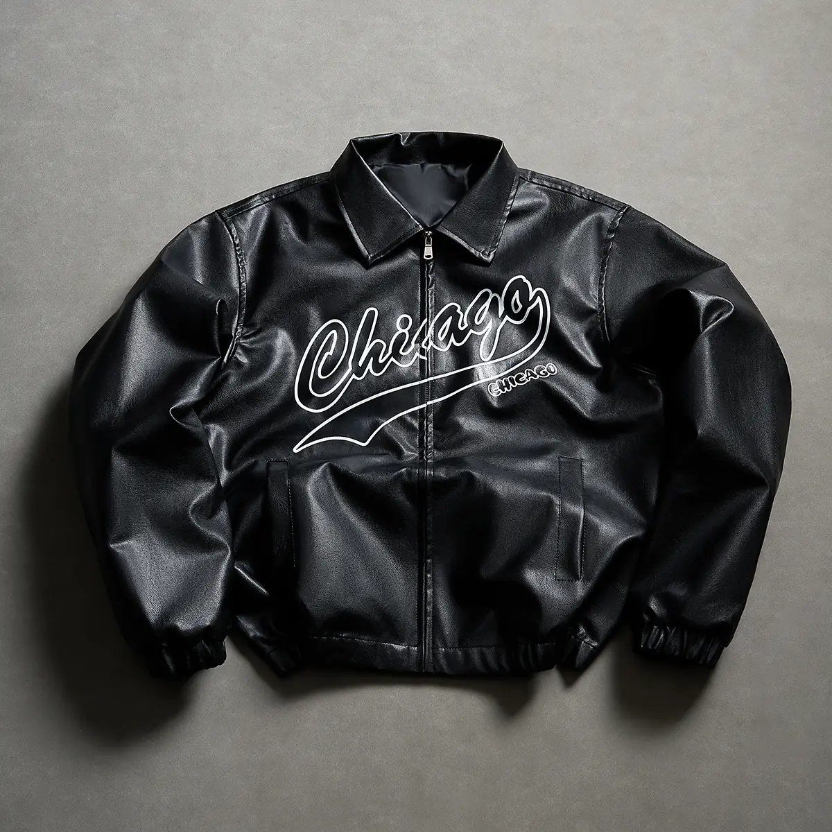 One men’s black PU leather short jacket with a turn-down collar; textured casual top made from matte faux leather that maintains a flat silhouette for long-lasting wear. Features double layers and large English lettering prints, with solid printing detail