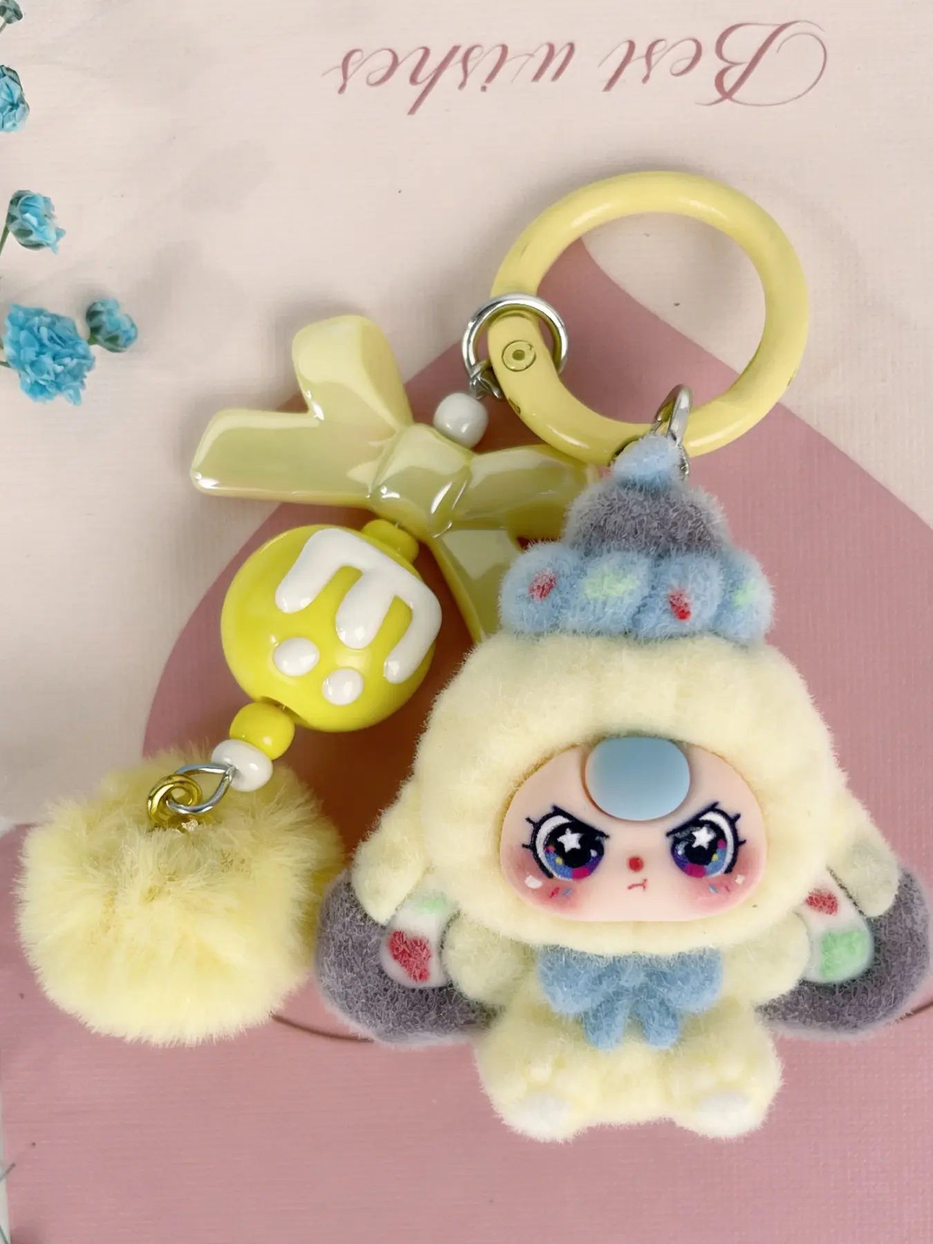 A cute pendant, Cute keychain, featuring a multi-colored plush doll as the main element, paired with a bow and pom-pom, with a sweet and dreamy style, suitable for hanging on bags or keys, adding a girlish and lively atmosphere to everyday outings