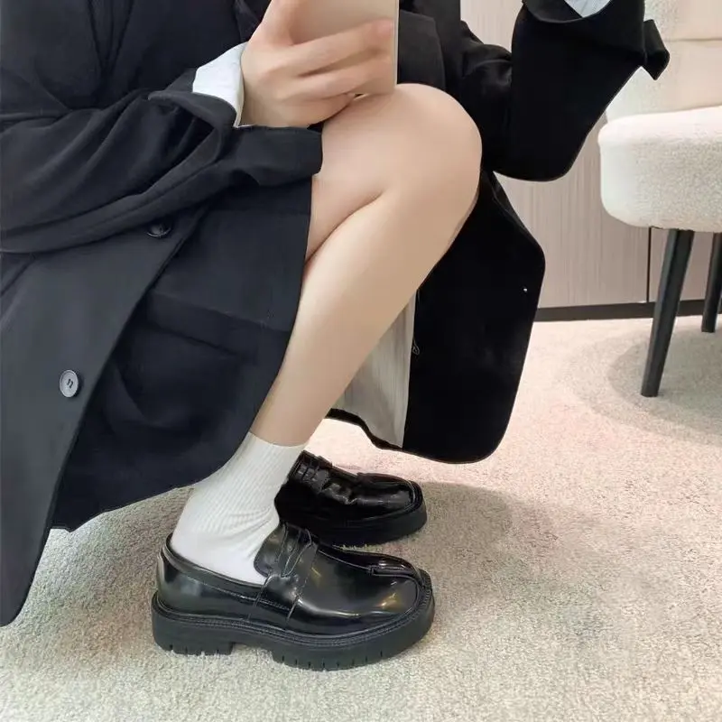 Minimalist unisex loafers, glossy patent leather slip-on shoes with thick soles, available in multiple colors, non-slip casual shoes—an everyday item for street photography and campus wear.