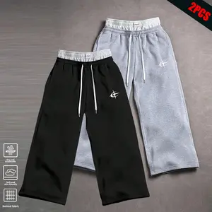 Clean Gent 2-piece men’s loose-fit jogger pants set featuring a drawstring elastic waistband and wide legs with pockets—comfortable for everyday wear and ideal as athletic bottoms. Sweatpants Logo-Embroidered Grey