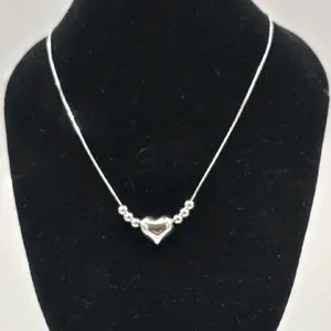 Sterling silver puffed heart bead necklace, featuring a small heart pendant on a snake chain with accompanying silver beads. 18 inches