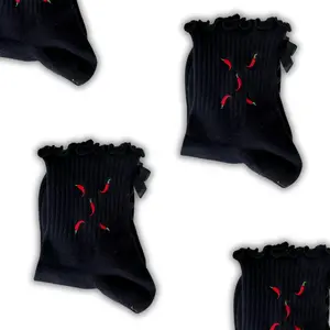 Black ruffle grip socks with chili peppers embroidered on it and a black bow with black heart grips for Pilates, Yoga, Lagree or Barre