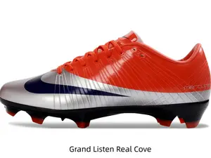 Vibrant orange silver gradient soccer cleats with dark navy graphic and red traction studs