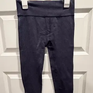 Dark blue athletic leggings with a ribbed design.