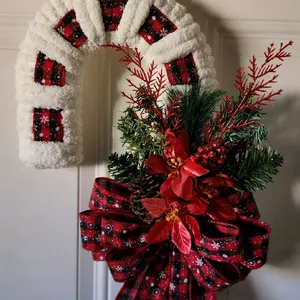 Handmade Christmas Candycane Wreath wrapped in soft, fluffy, white chunky Chanille yarn and buffalo plaid ribbon, and topped with a custom made festive red foliage bundle. This Candycane Wreath would be the perfect decor to add to any door or windows.