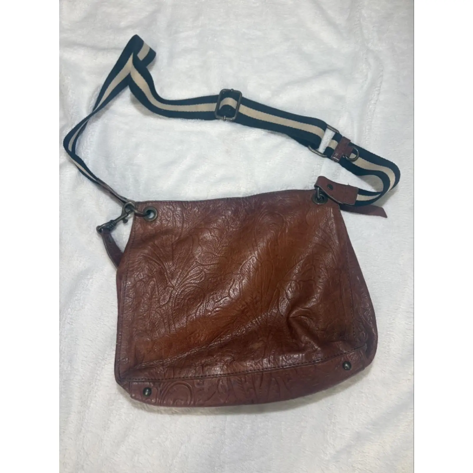 Used Textured Brown Leather Crossbody Bag with Striped Adjustable Strap Embossed Floral Detail Secure Metal Hardware Versatile Design