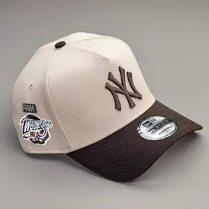 9FORTY New York World Series Side Patch Baseball Cap – Cream color, adjustable size, brown NY logo.