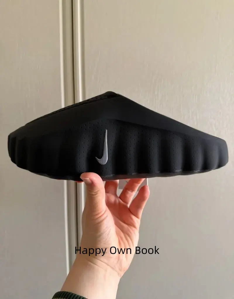 Solid matte full-black monochrome slide clogs, soft molded foam construction, bright orange circular inner sole accents create cool contrast for dark casual, athletic & streetwear fits