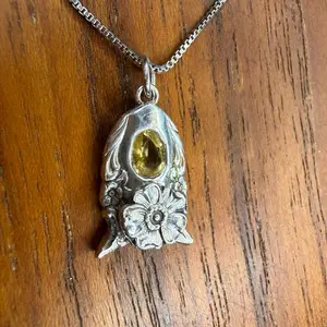 Yellow sapphire, and Sterling Silver poppy pendant made from an antique Sterling Silver spoon. This is a .75 carat no heat light butter, yellow natural sapphire.