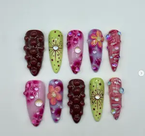 Vibrant fruity-inspired nail set with grape-like 3D textures, colorful floral accents, and shimmering details for a bold, playful, and summery vibe