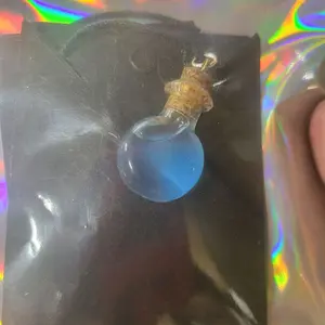 Blue Sparkling Potion in Small Flat Bottle with Long Lasting UV Glow Necklace Featuring Cork Stopper Design on Choker Necklace