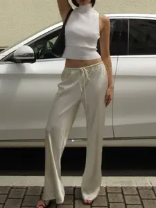 A pair of women's off-white satin drawstring wide-leg pants, featuring a smooth texture and a relaxed, loose fit, suitable for casual occasions such as light urban office wear, afternoon tea outings, and leisurely dates, Casual Comfy Trouser