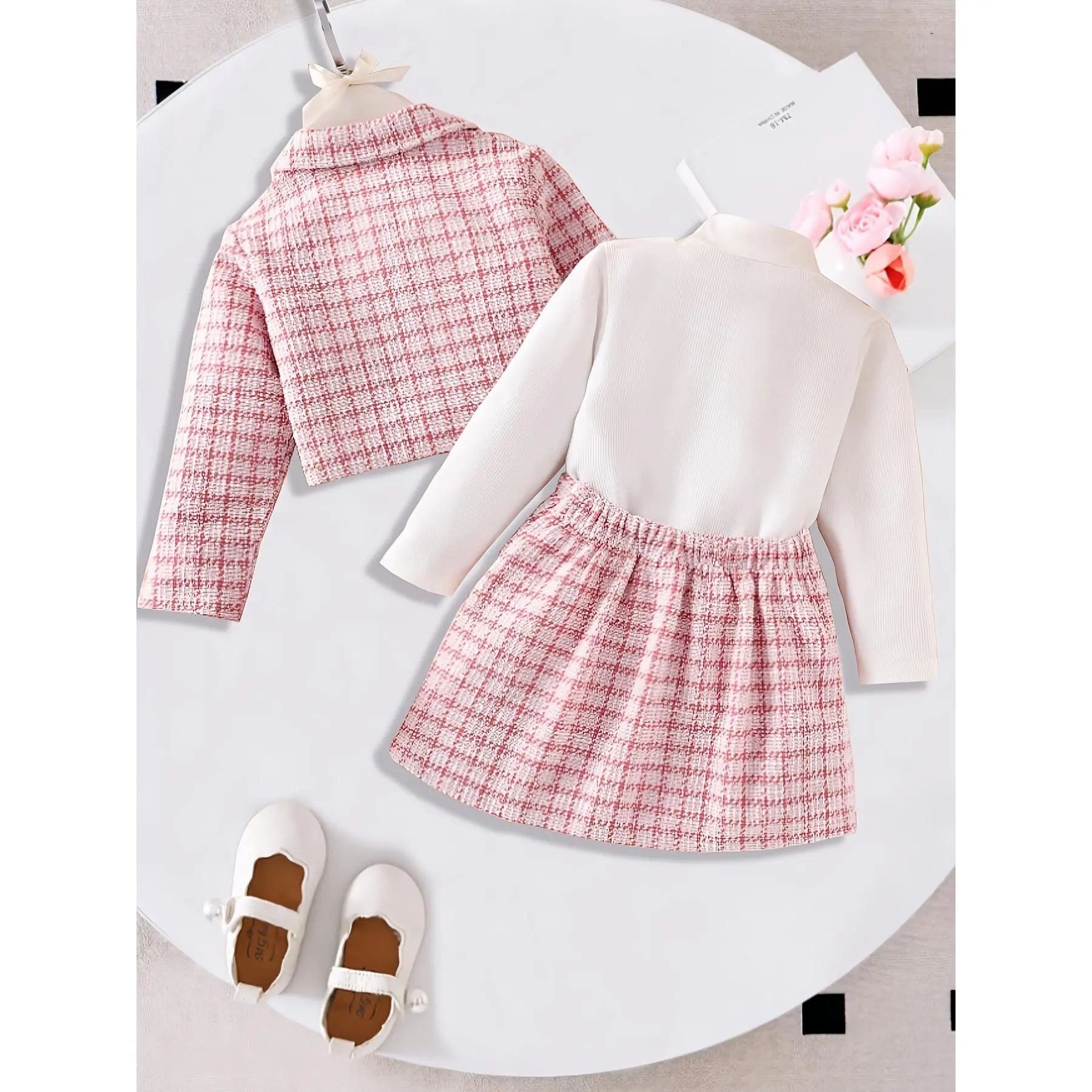 A Stylish Spring And Autumn Outfit for Young Girls Featuring an Elegant Pink Checkered Long-Sleeve Coat Paired with a Long-Sleeve White Top And a Checkered Pleated Skirt, All in a Three-Piece Set