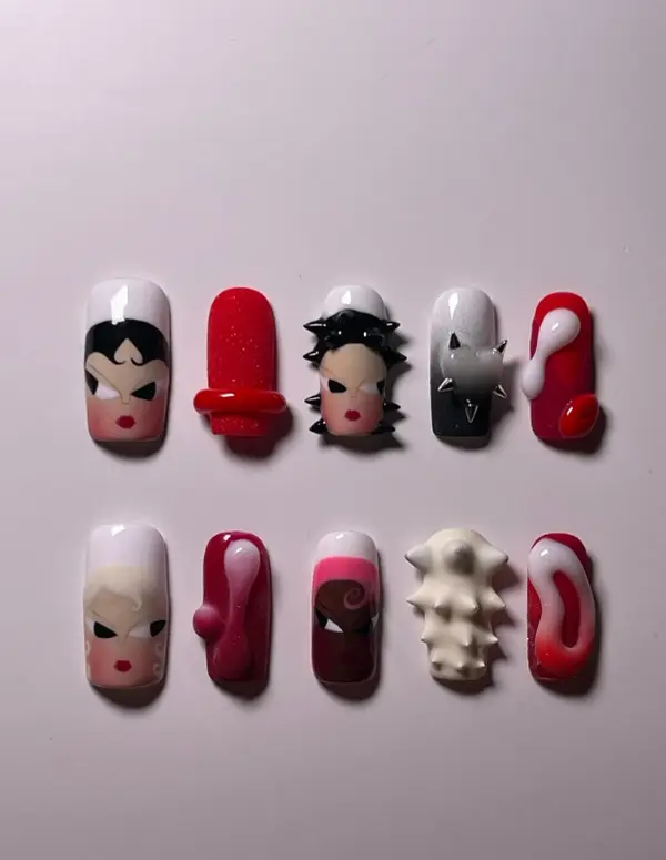 Edgy character-inspired nail art featuring bold female faces, 3D spikes, textured abstract shapes, and vibrant red-black gradients for a fierce statement.