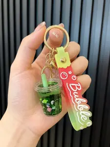 A keychain pendant in the shape of a milk tea cup with flowing oil sand simulation, suitable for daily wear, vacations, dates, and other occasions, and also a delightful and exquisite small gift.