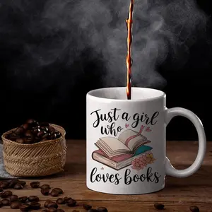"Just a Girl Who Loves Books" 11oz ceramic mug. White book-themed design in cursive font. Perfect gift for female readers, bookworms, or Halloween/Christmas. Hand-wash only