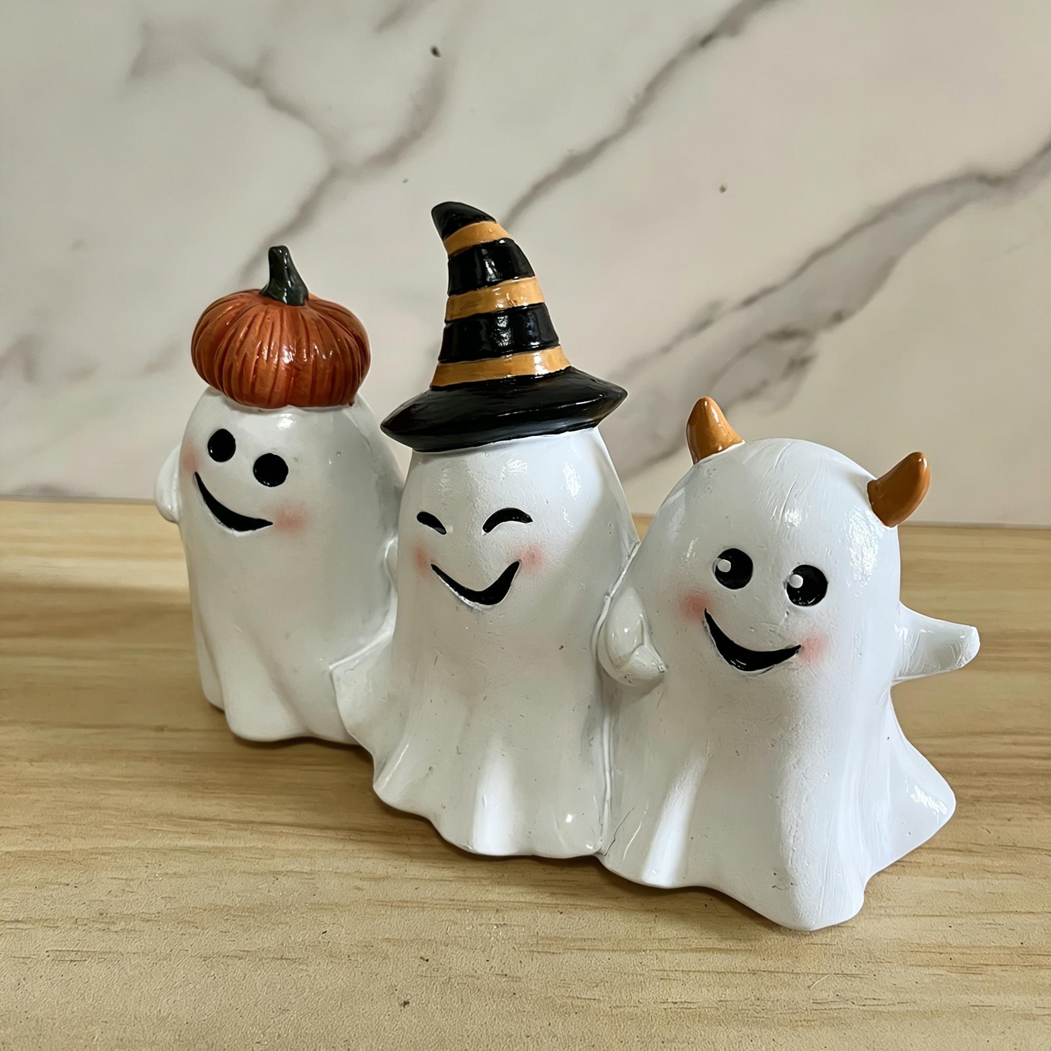 The whimsical trio of Smiling Ghosts - a group of people with crazy smiles - are decorating pumpkins as witches and devils for Halloween.