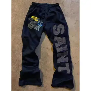 Deep blue drawstring-waist sports pants with “SAINT” print and graphic elements, ideal for streetwear and avant-garde styling GARMENTARY
