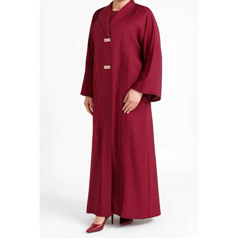 This is a luxurious  Dubai abaya, showcasing a sophisticated and elegant design in a rich burgundy color. It features a flowing, full-length silhouette with subtle pleated detailing along the front and sleeves, adding refined texture and graceful move eid