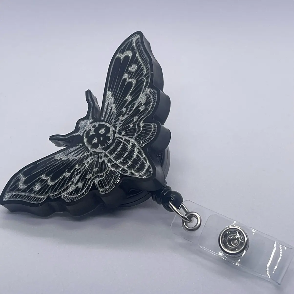 Black and silver deadhead moth badge reel