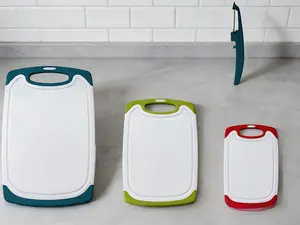4-piece plastic cutting board set for kitchen use. Equipped with non-slip feet and deep juice grooves, plus easy-grip handles. Fully dishwasher safe for simple daily cleaning.