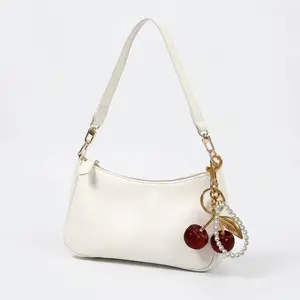 Elegant cherry pendant crossbody bag; spring new moon-shaped shoulder bag; cherry charm with pearl chain decoration; zippered crossbody bag with chain strap; elegant solid-color handbag; women’s underarm/square mini bag; a refined handbag for girls