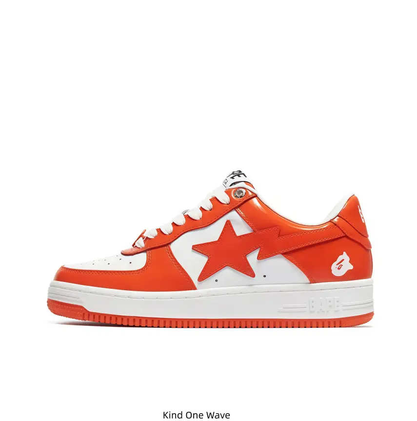 Orange and white color-block BAPE STA low-top sneakers, orange star logo on the side, ape head emblem, brand marking on the heel, white midsole with orange outsole, bright casual street footwear for daily outfits and sneaker collection