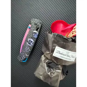 535 Outdoor Multi-Tool, carbon-fused handle, 3D-printed skull texture, laser-etched patterns with vibrant hues, vacuum-coated to achieve a titanium-like purplish-red finish, made of high-hardness Damascus steel