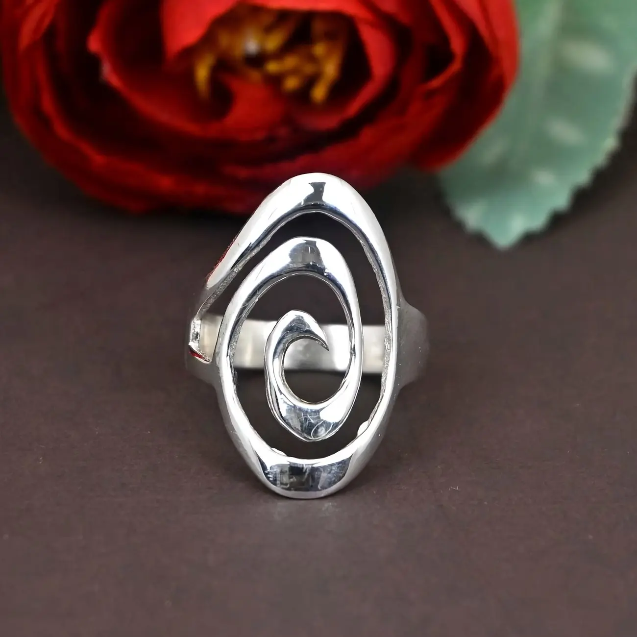 A minimalist bohemian-style ring featuring a sleek, flowing spiral pattern at its core. The polished copper finish gives this simple ring a clean, refined look, making it perfect for everyday wear.