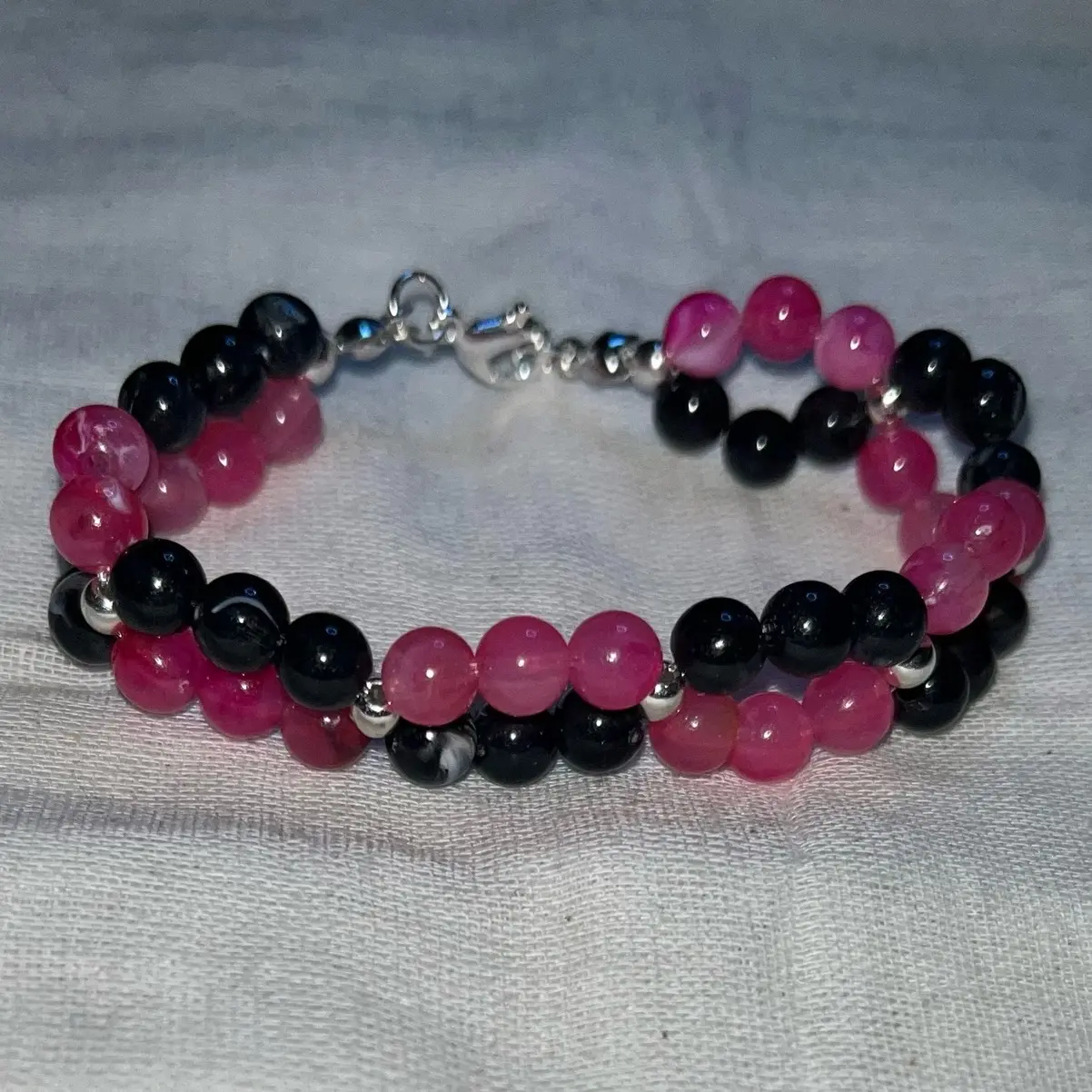 Twisted pink and black bead bracelet.