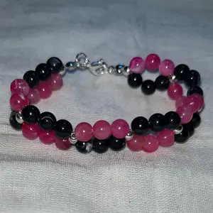 Twisted pink and black bead bracelet.