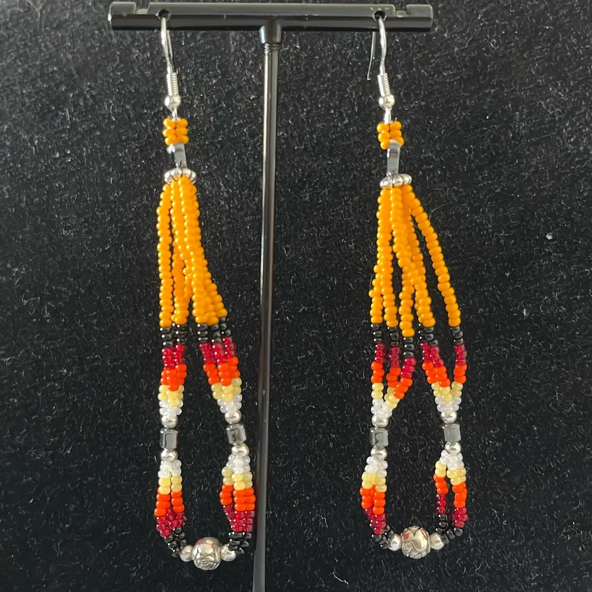 Navajo handmade beaded earrings adorned with orioles orange seed beads, fire designed seed beads, hematite and heart shaped hematite stones.