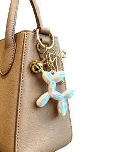 1x Gold Bow & Bell Charm — Balloon Dog Keychain. High-Gloss Iridescent Resin Puppy. Handbag Charm / Car Keychain. A perfect gift for sweet girls, students, "soft-style" enthusiasts, young women, and lovers of trendy accessories.
