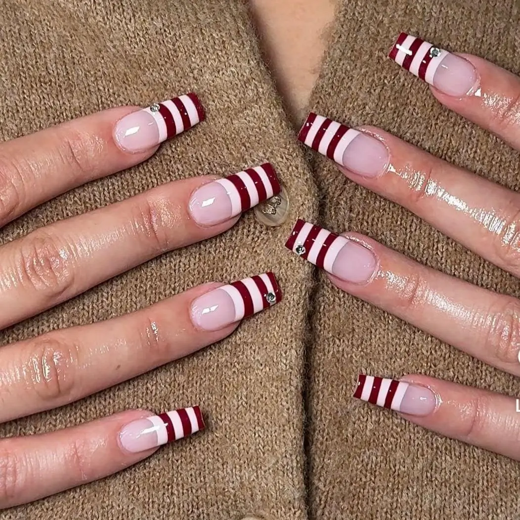 Chic Nail Studio Red Stripe Holiday Press-On Nails – Clean nude base with bold red stripe French tips, modern elegant style, ideal for summer vacation, city travel, spring outfits, timeless chic nail studio aesthetic.