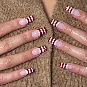 Chic Nail Studio Red Stripe Holiday Press-On Nails – Clean nude base with bold red stripe French tips, modern elegant style, ideal for summer vacation, city travel, spring outfits, timeless chic nail studio aesthetic.