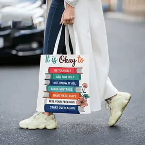 This motivational canvas tote bag features a stack of colorful books with uplifting messages like Be Yourself Ask For Help and Start Over Again making it a perfect eco friendly accessory for daily Eco Friendly Totes