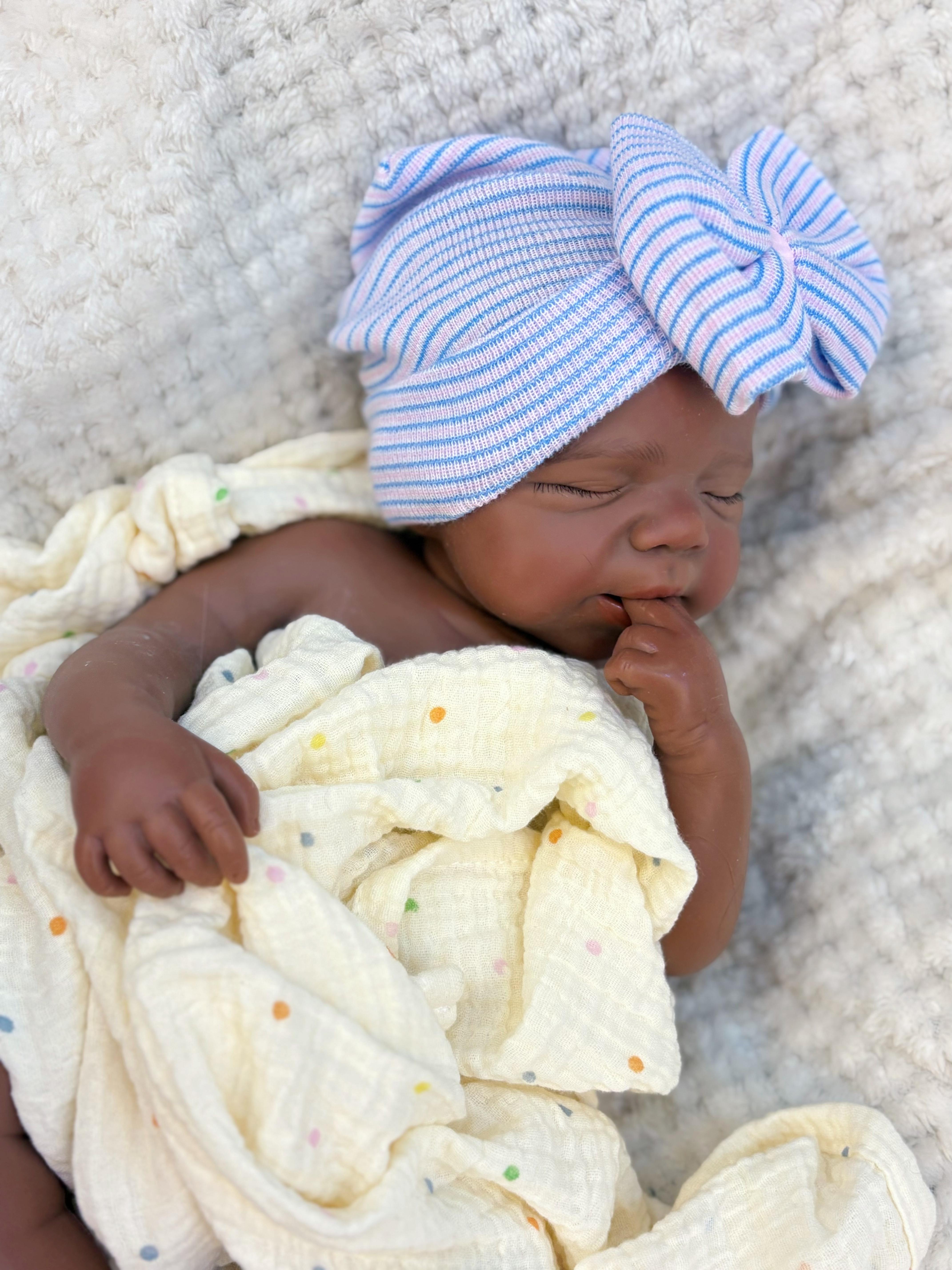 Reborn doll, soft silicone — 18 inches tall, lifelike with closed eyes for sleeping, brown skin, a soft body, and realistic detailed features. Includes a comfort item, a bottle, and a birth certificate. Perfect for birthday gifts, collectors, and children